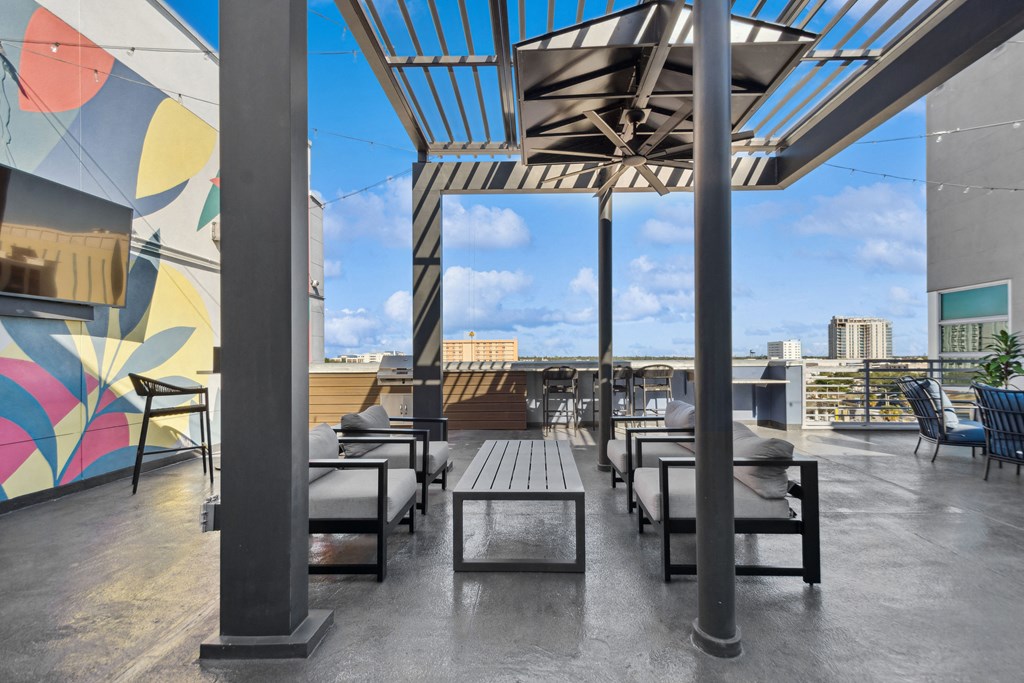 a rooftop patio with tables and chairs and a view of the city
