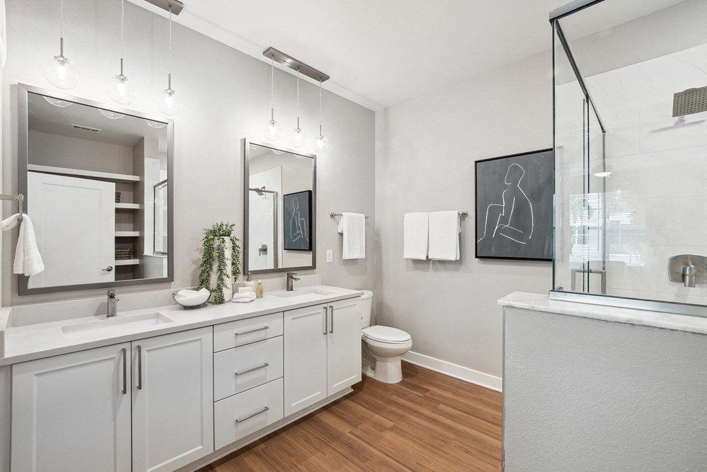 a bathroom with white cabinets and a mirror and a toilet