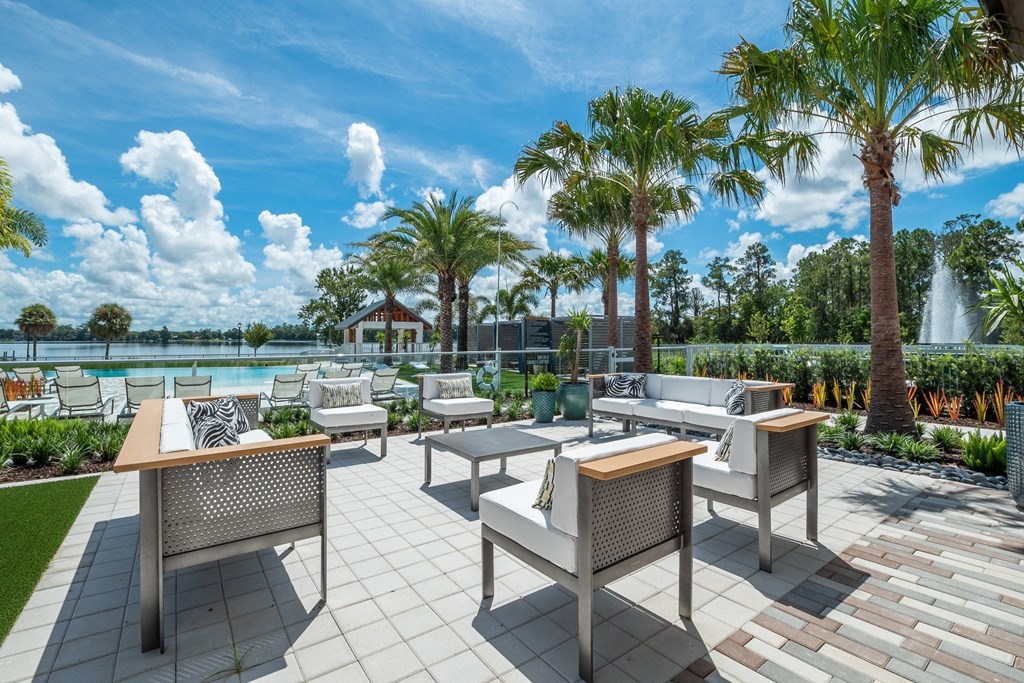 a patio with tables and chairs overlooking the water