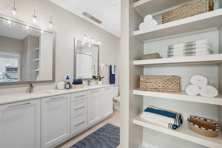 a bathroom with white cabinets and a sink and a mirror