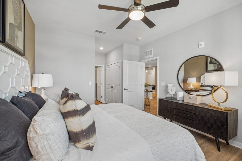 a bedroom with a large bed and a ceiling fan