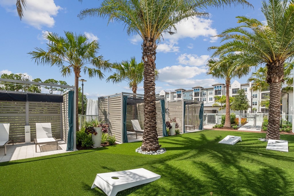 a backyard with palm trees and a seating area and a pool