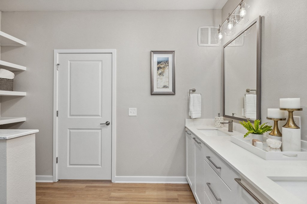 a bathroom with a white door and a sink and a mirror