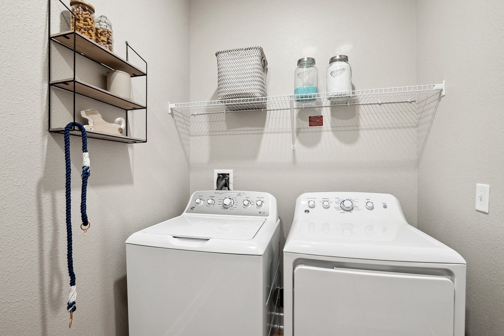 an empty laundry room with two washes and a dryer