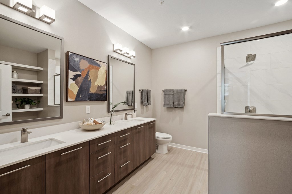 a bathroom with two sinks and a shower with a glass door