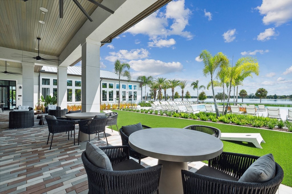 a patio with tables and chairs overlooking the water at the resort