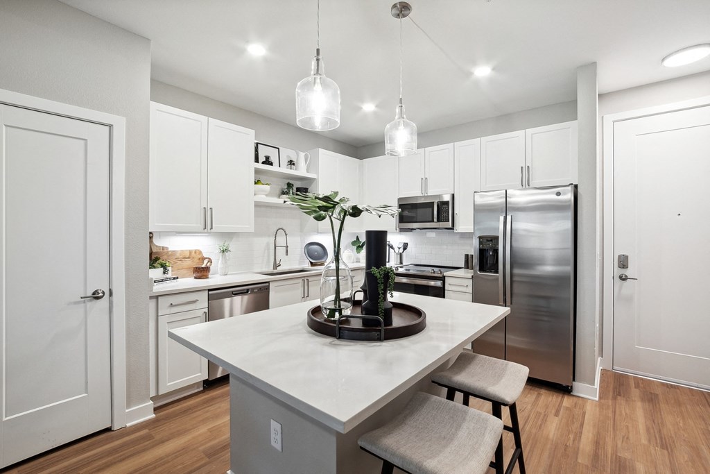a renovated kitchen with white cabinets and stainless steel appliances