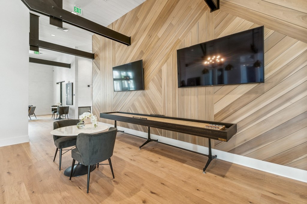 a living room with a table and a tv on the wall