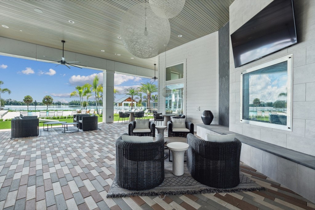 a patio with tables and chairs and a view of the water