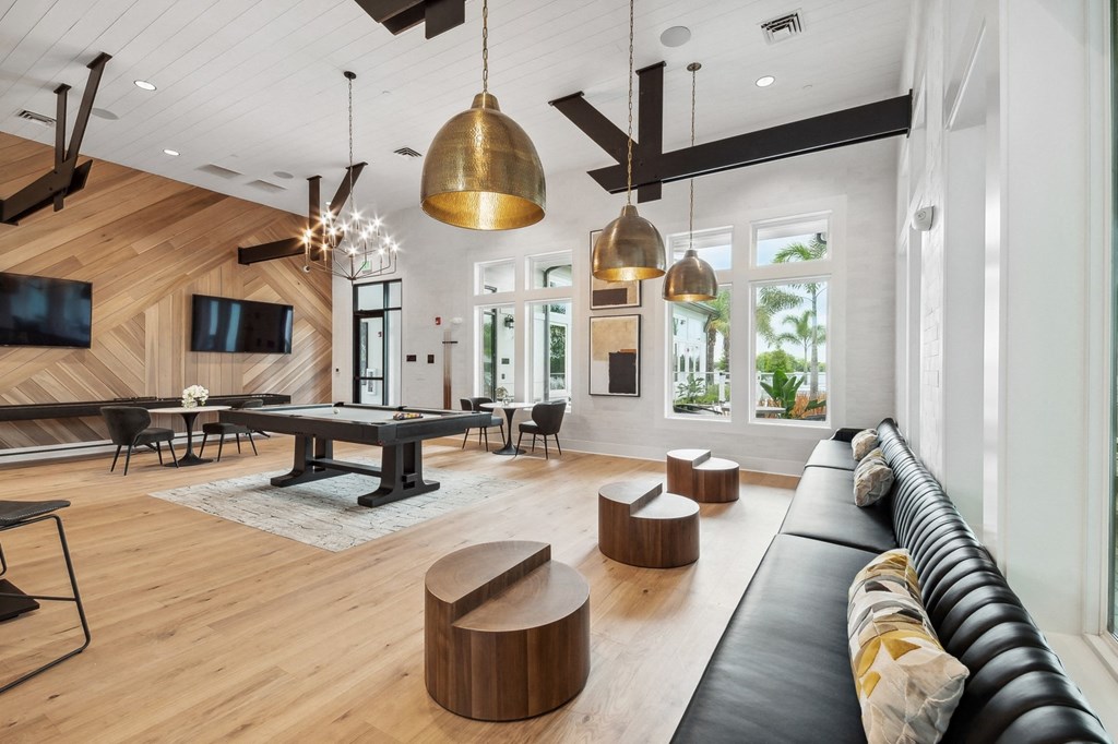 a large living room with a pool table and couches
