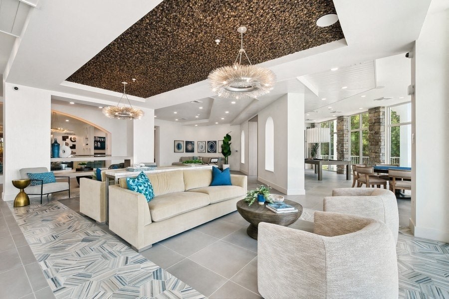 a living room with white couches and chairs