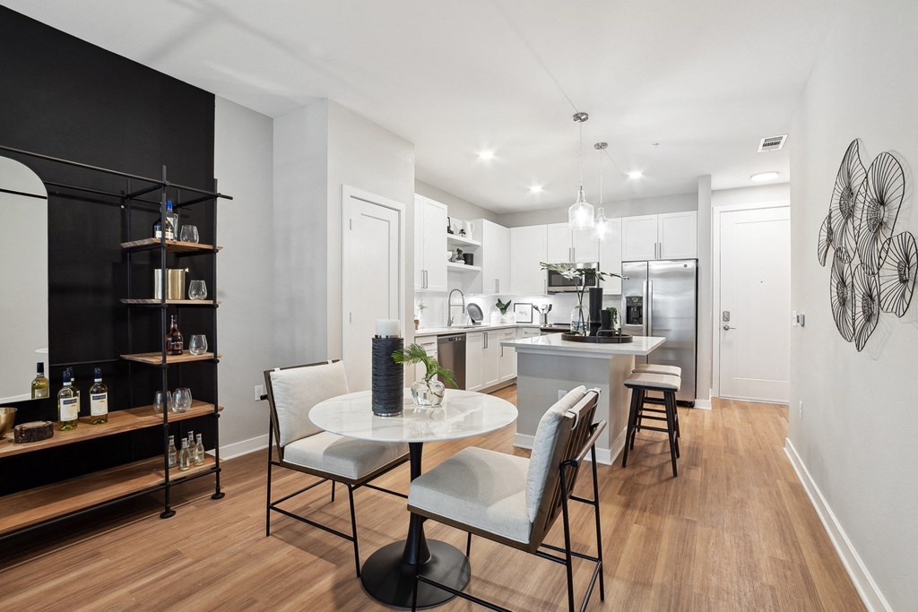 a living room and kitchen with a table and chairs