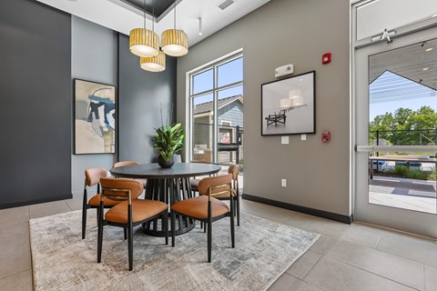 A dining room with a round table and chairs.