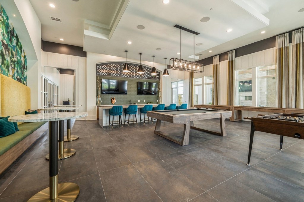 a game room with tables and chairs and a television