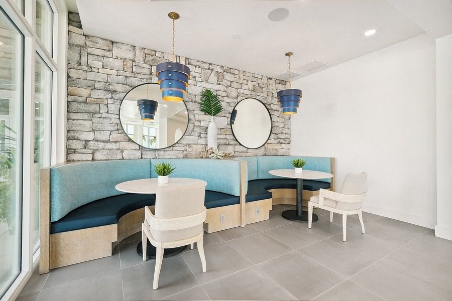 a dining room with tables and chairs and a stone wall