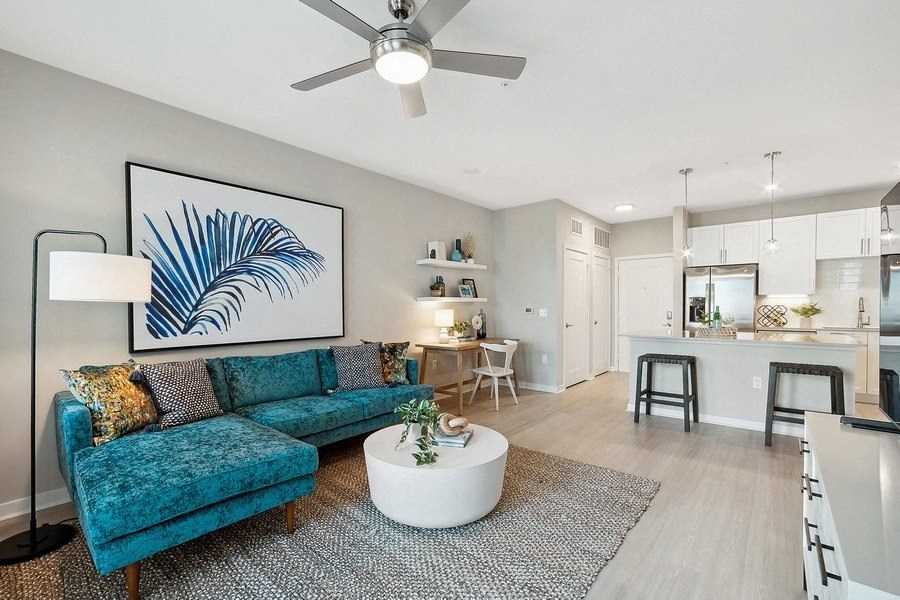 a living room with a blue couch and a white table
