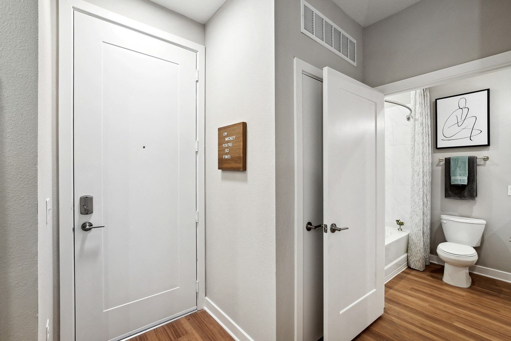 a bathroom with a white door and a toilet and a shower