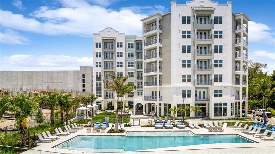 a large swimming pool in front of an apartment building
