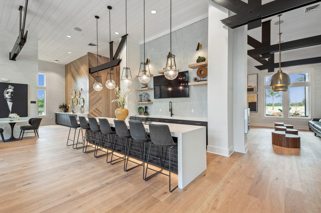 a large kitchen with a long island and chairs in front of a white counter top