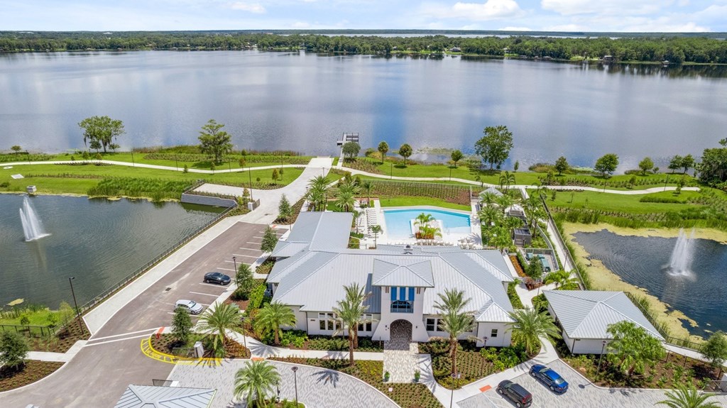 an aerial view of a house with a swimming pool and a lake