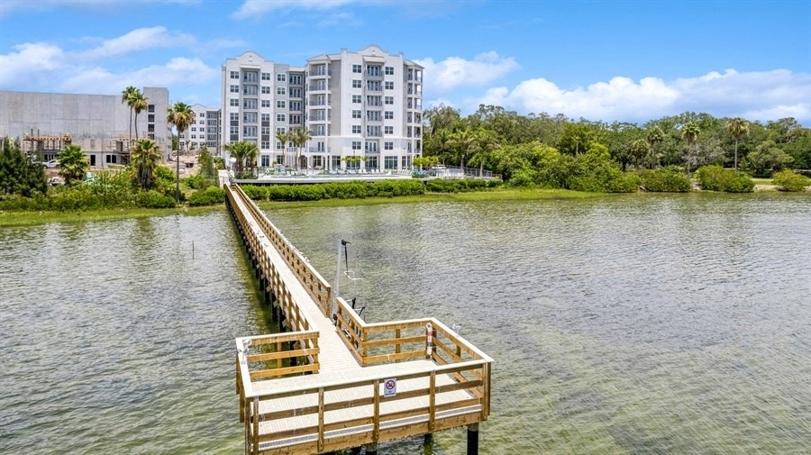 a dock on a lake with a building in the background
