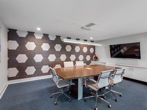 A conference room with a brown and white patterned wall and a wooden table.