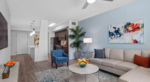 A living room with a blue chair and a white couch.