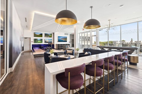 A modern kitchen with a bar area and a view of the city.