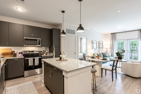 A modern kitchen with dark brown cabinets and a white island.