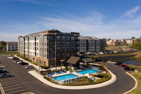 A large building with a pool in front of it.