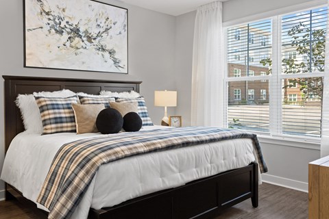 a bedroom with a bed and two windows