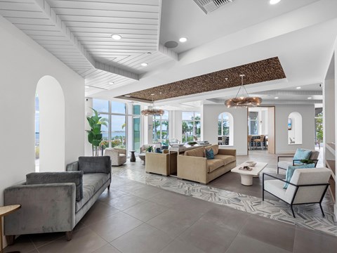 A spacious living room with a large grey sofa and a wooden side table.