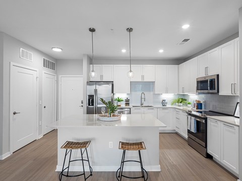 A modern kitchen with white cabinets and a central island.