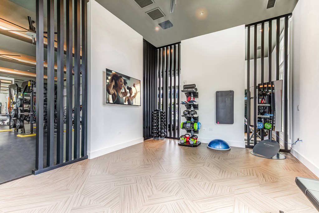 a home gym with a wood floor and black dividers