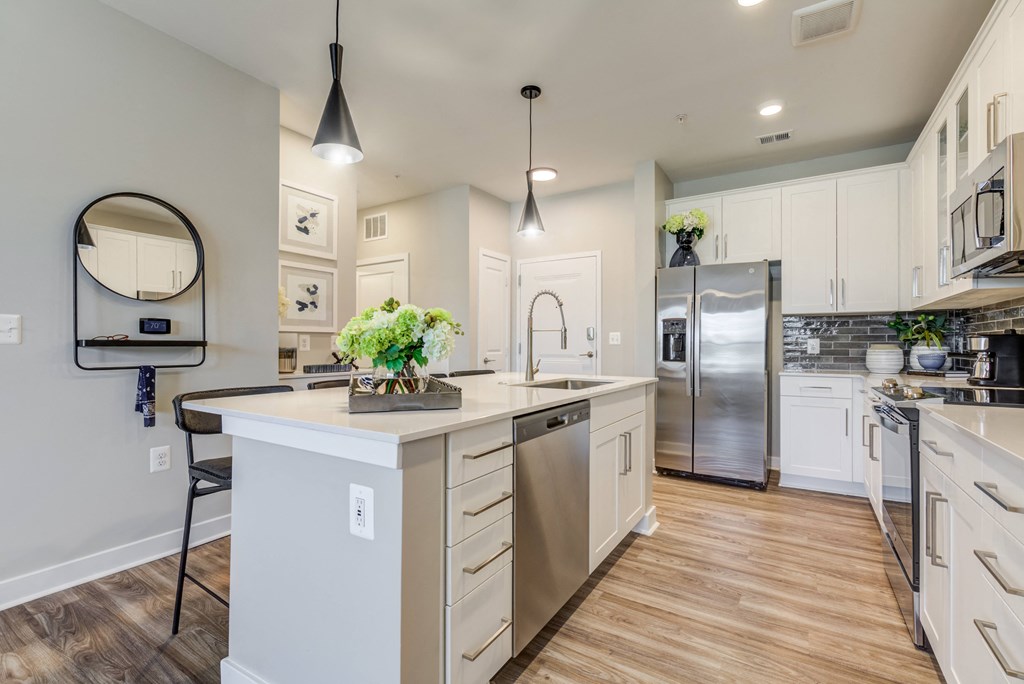 a large kitchen with an island and stainless steel appliances