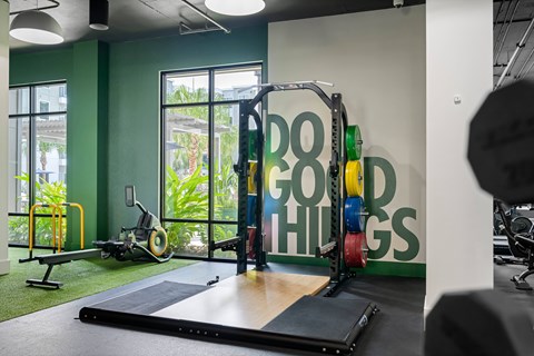 A gym with a green wall and a sign that says "Good Things".