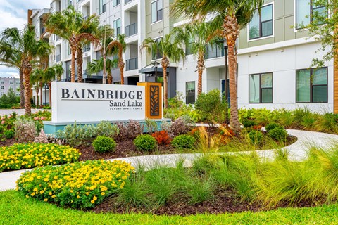 A sign for Bainbridge Sand Lake is in front of a building.