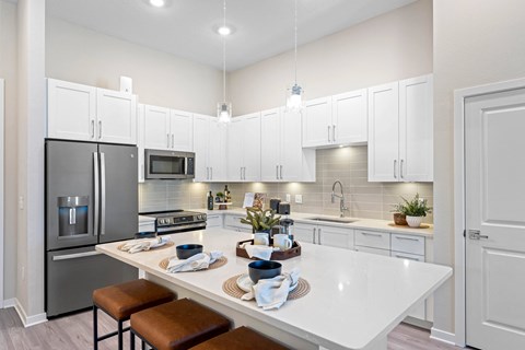 A modern kitchen with white cabinets and a large island.