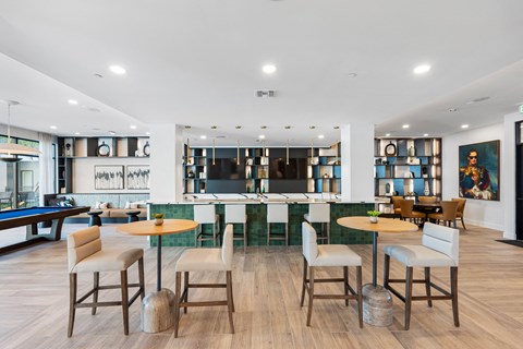A room with a pool table and a bar area.
