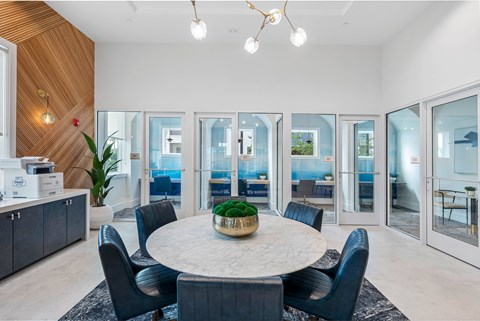 A modern dining room with a round table and chairs.