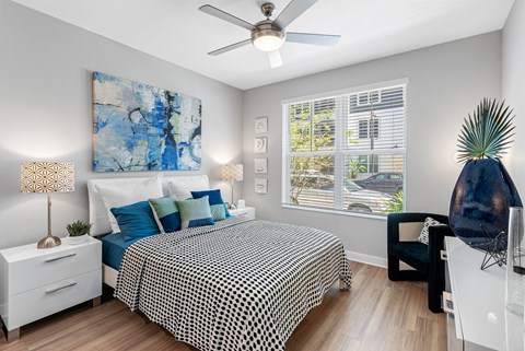 A bedroom with a large bed and a ceiling fan.