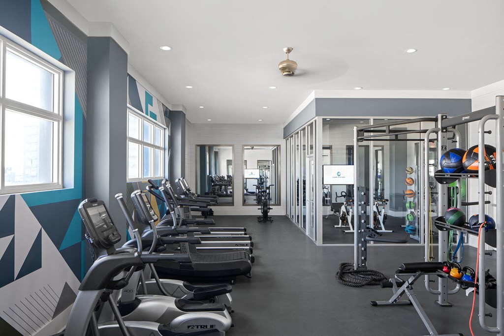 a gym with various cardio machines and weights