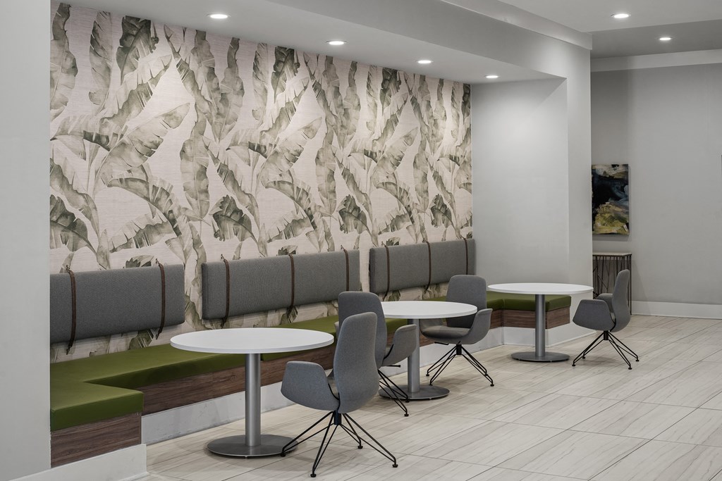 a seating area with tables and chairs in a room