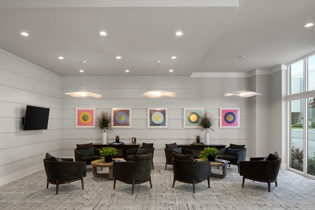 a large lobby with chairs and tables and a television