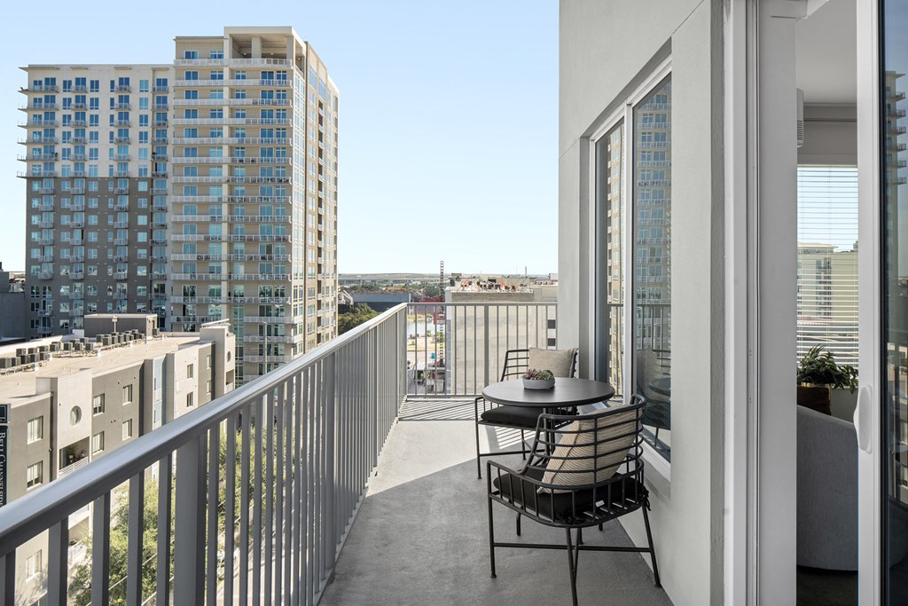 a balcony with a table and chairs and a view of the city