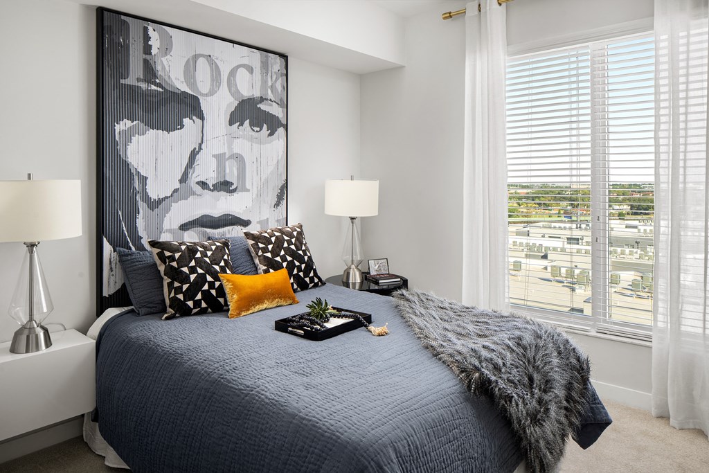 a bedroom with a bed and a large picture of rock on the wall