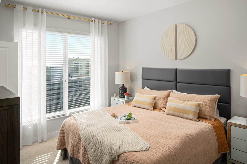 a bedroom with a bed and a large window