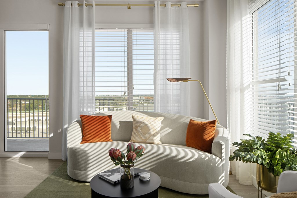 a living room with a white couch and orange pillows