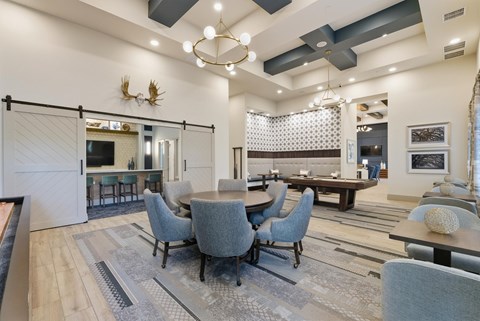 A modern dining room with a large table and grey chairs.