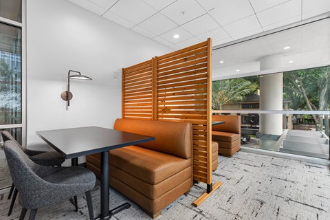 A modern dining room with a table, chairs, and a wooden slat partition.